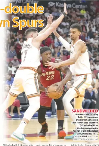  ?? PHOTO BY REBECCA BLACKWELL/AP ?? SANDWICHED Miami Heat forward Jimmy Butler (22) comes under pressure from San Antonio Spurs forward Doug McDermott (17) and center Victor Wembanyama during the first half of an NBA basketball game, Wednesday, Feb. 7, 2024, in Miami.