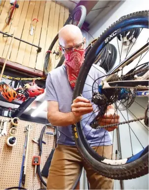  ?? STAFF PHOTOS BY ROBIN RUDD ?? Mike Skiles, owner of Suck Creek Cycle, overhauls a bicycle in his North Chattanoog­a shop on Tuesday. Cycling is seeing a boom during the COVID-19 pandemic.