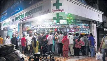  ?? REUTERS ?? People gather at a Mumbai pharmacy to buy supplies after the lockdown was announced on Tuesday.