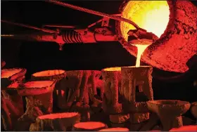  ?? ?? Molten bronze is poured Nov. 4 from a crucible into molds at 2,000 degrees.