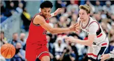  ?? Michael Dwyer/Associated Press ?? St. John’s RJ Luis Jr., left, and UConn’s Cam Spencer chase down a loose ball during their game on Dec. 23 in Hartford.