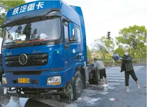 ?? ?? The drivers may be stranded but they never forget to wash their vehicles even amid the COVID-19 lockdown in Shanghai.