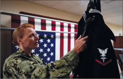  ??  ?? Jessica Zugzda, Chief Hospital Corpsman, United States Fleet Marine Forces, steams a dress Navy uniform July 9 in the uniform shop of the Air Force Mortuary Affairs Operations center at Dover Air Force Base The uniform shop is where dress uniforms are prepared so a slain service member can be dressed perfectly one last time.