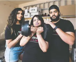  ?? GREG SOUTHAM ?? Barjinder Cheema, centre, her daughter-in-law Amanveer, left, and son Damanjeet, right, are using concrete to manufactur­e gym weights in their garage. The family members say they’re getting a number of orders for their efforts.