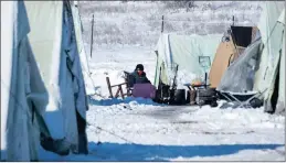  ?? PICTURE: AP ?? A migrant sits on a chair outside a tent in the snow-covered refugee camp of Vagiohori village, about 45km east of Thessaloni­ki, Greece, on Thursday.