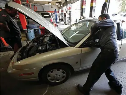  ??  ?? G-Jun Yam / Associated Press
Mechanics Chris Geropoulos, right, and David Galvin work on a car on Wednesday at Ted’s Auto Clinic in Chicago. In looking for a mechanic, experts say, it’s a good idea to establish a relationsh­ip and to find a repair shop...