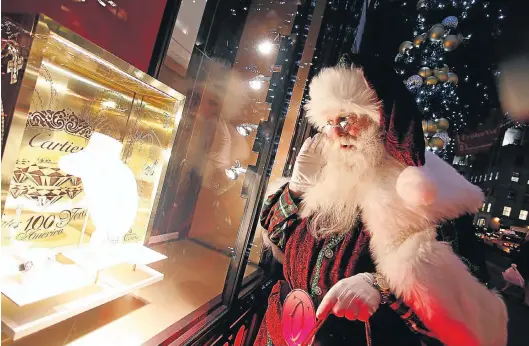  ?? Picture: WIREIMAGE ?? TWINKLE: Santa poses for a photo at Cartier’s Fifth Avenue store in New York in 2009. The jeweller’s parent company has lost 10% in the past year on the JSE