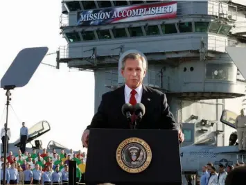  ??  ?? Left, U.S. President George W. Bush declares “Mission Accomplish­ed” aboard the USS Abraham Lincoln on May 1, 2003. Right, Russian President Vladimir Putin speaking at the Kremlin in Moscow