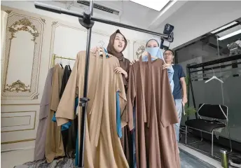  ?? ?? Students wearing abaya gowns and hijabs practising live streaming on TikTok at Mede Education Technology’s ecommerce school in Guangzhou, in southern China’s Guangdong province.