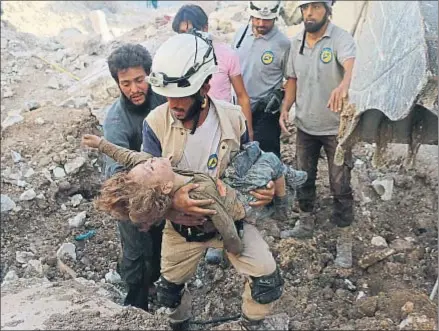  ?? AMEER ALHALBI / AFP ?? Un miembro de los equipos de rescate, los cascos blancos, lleva a un niño, víctima de los bombardeos ayer