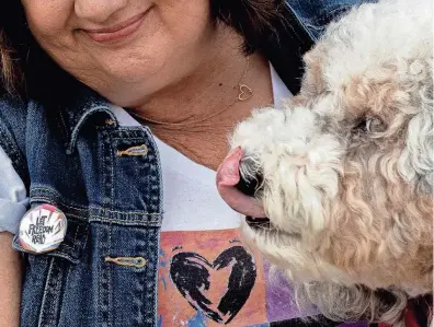  ?? PHOTOS BY SAÚL MARTINEZ FOR USA TODAY ?? Diana Haneski has been a librarian at Marjory Stoneman Douglas High School for nine years. She and her dog, River, offer students and staff alike a place to escape and relax.