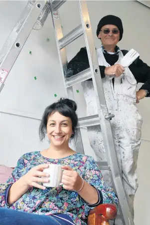  ?? PHOTO: RICHARD DAVISON ?? Teamwork . . . Rex Brumby applies finishing touches to the Neux Bar & Kitchen at Port Molyneux School in Kaka Point, while owner Jade McNab enjoys a cafe beverage, in preparatio­n for the venue hosting the town’s annual Community Market on Sunday.