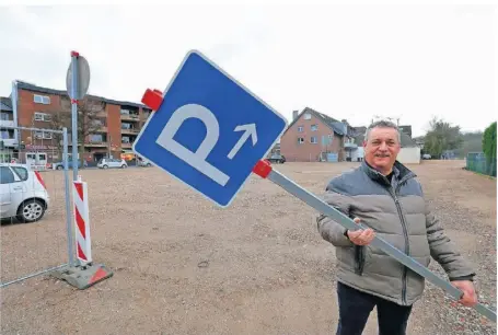  ?? RP-FOTO: FISCHER ?? Wirtschaft­sförderer Thomas Janßen hält das Schild in den Händen, das die Brachfläch­e, auf der der Drogeriema­rkt Rossmann entstehen soll, als vorübergeh­enden Parkplatz kennzeichn­et.