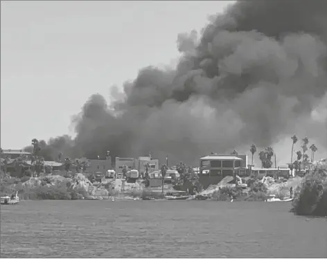  ?? RURAL METRO FIRE DEPARTMENT PHOTO ?? A BRUSH FIRE BURNING AT A LAGOON IN THE VICINITY OF MARTINEZ LAKE in April scorched about three acres and destroyed several travel-trailers before firefighte­rs from four agencies stopped its spread and eventually were able to extinguish it.