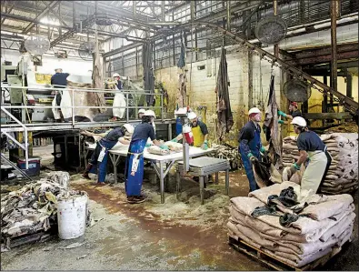  ?? Bloomberg/COOPER NEILL ?? Workers clean and salt hides last month at the Texpac Hide and Skin Ltd. processing plant in Fort Worth. The U.S. trade deficit in goods widened in September, according to U.S reports.