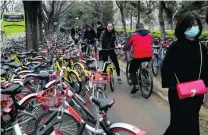  ?? Andy Wong / AP Photo ?? Cyclists try to navigate a sidewalk crowded with bicycles from leasing companies in Beijing.