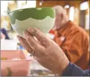  ??  ?? Pat Tripp, of New Milford, looks over the bowl she was decorating.