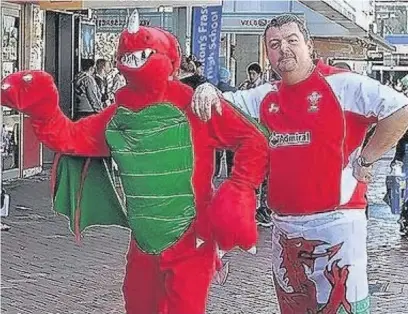  ??  ?? Dorian Caudy pictured in New Zealand with a Welsh rugby fan dressed as a dragon