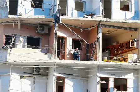  ?? — Reuters ?? No place like home: A man sitting on the balcony of his damaged house in the rebel held al-Sukkari neighbourh­ood of Aleppo.