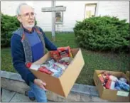  ??  ?? Tom Bare of the Church of the Loving Shepherd in West Chester loads Thanksgivi­ng baskets at Mount Carmel Church for Saturday delivery.