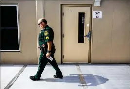  ?? NEW YORK TIMES ?? A police officer patrols Marjory Stoneman Douglas High School in Parkland, Florida, where a student massacre unnerved school administra­tors across the country. The summer was devoted to reinforcin­g buildings and hiring security.