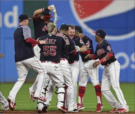  ?? DAVID DERMER — THE ASSOCIATED PRESS ?? Jay Bruce, center, celebrates with teammates after driving in the winning run with a double off Royals relief pitcher Brandon Maurer during the 10th inning on Sept. 14 at Progressiv­e Field.
