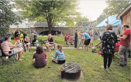  ?? PETER LEE WATERLOO REGION RECORD ?? Neighbours gather in the backyard of a home on Louisa Street for a pig roast on on the Labour Day weekend.