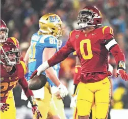  ?? MARK J. TERRILL/AP ?? Southern California defensive end Korey Foreman, right, celebrates with defensive back Bryson Shaw, second from left, and defensive lineman Brandon Pili after intercepti­ng a pass during the second half against UCLA on Saturday in Pasadena, Calif.