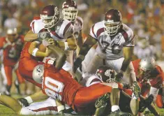  ?? NEW MEXICAN FILE PHOTO ?? Gonzales’ plan in rebuilding the moribund program involves uncovering local players who can be big contributo­rs, like Nick Speegle, left, shown attempting to sack the Washington State quarterbac­k in 2004.
