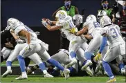  ?? ISAAC BREKKEN/ASSOCIATED PRESS ?? Los Angeles Chargers quarterbac­k JustinHerb­ert (10) scores a touchdowna­gainst the Las Vegas Raiders in overtimeof anNFL football game Thursday in Las Vegas.