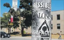  ?? CLIFFORD SKARSTEDT EXAMINER ?? A pedestrian walks past one of the poles plastered with posters scattered along George St. on Friday.