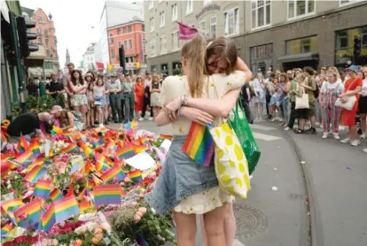  ?? SERGEI GRITS/AP ?? Two women embrace as they lay flowers Saturday at the scene of a shooting during a Pride festival in Oslo, Norway.