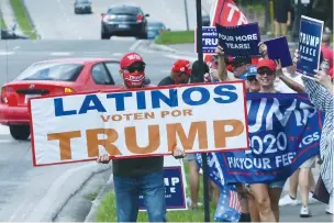  ?? ( Paul Hennessy/ NurPhoto via Getty Images) ?? PEOPLE HOLD placards after Vice President Mike Pence addressed supporters at a Latinos for Trump campaign rally at Central Christian University in Orlando, Florida, earlier this month.