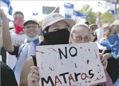  ?? AFP Photo / Marvin Recinos ?? Una mujer, con un cartel que pone «No matarás», en el exterior de la catedral de Managua, el 14 de julio