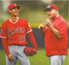  ?? Ben Margot / Associated Press ?? New Angels pitcher Shohei Ohtani (left) engages with manager Mike Scioscia during Wednesday’s workout in Tempe, Ariz.