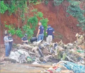  ??  ?? Policías y agentes del Ministerio Público observan el cuerpo sin vida de Carmelo Dejesús Ferreira Ocampos, en el cauce de un arroyo, en el límite entre Ñemby y Villa Elisa.