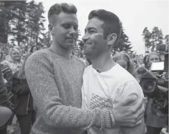  ?? ODD ANDERSEN/AFP/GETTY IMAGES ?? Mani Hussaini, right, president of the Norwegian Labour Party’s youth division, gets a hug from former leader Eskil Pedersen, who survived the attack by a right-wing extremist, at the Utoya island camp reopening on Friday.