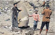  ??  ?? Egyptian workers, top, prepare to lift parts of the statue at the site in Matariyyah while local residents, left, rush to take pictures with the unearthed artefacts before their removal