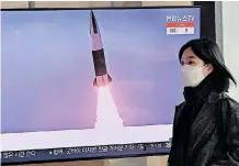  ?? | AFP ?? A WOMAN walks past a television screen at a railway station in Seoul last month showing a news broadcast of file footage of a North Korean missile test. North Korea hinted it could resume nuclear and long-range weapons tests.