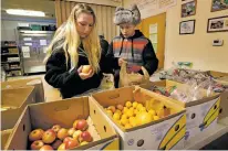  ?? ROBERT F. BUKATY/ASSOCIATED PRESS FILE PHOTO ?? From left, Sunny Larson and Zak McCutcheon pick produce in March at a Food Bank in Augusta, Maine. Republican Gov. Paul LePage says his call to ban the use of food stamps for soda and candy is backed by science and a desire to reduce obesity in the...