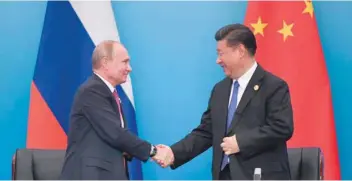  ?? — AFP ?? Xi Jinping (R) with Vladimir Putin after a signing ceremony during the SCO summit in Qingdao on Sunday.