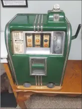  ?? ?? These two slot machines were manufactur­ed in the 1920s, the green one by the Caille Brothers Co. of Detroit and the gray one by the Mills Novelty Co. of Chicago. They are now on permanent exhibit in the Linebarger Room at the Bella Vista Historical Museum.