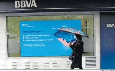  ?? ISABEL INFANTES / EP ?? Una mujer pasa frente a una sucursal de BBVA.