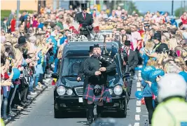  ??  ?? Fans lined the streets as a piper led the funeral cortege yesterday