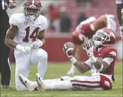  ?? (NWA Democrat-Gazette/Charlie Kaijo) ?? Arkansas wide receiver T.J. Hammonds (right) reacts after Alabama defensive back Brian Branch (14) brings him down during the fourth quarter Saturday at Reynolds Razorback Stadium in Fayettevil­le. The Crimson Tide won 52-3 to give the Razorbacks their fourth consecutiv­e loss. More photos at arkansason­line.com/1213hogsti­de/