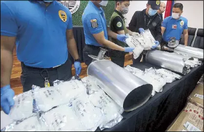  ?? RUDY SANTOS ?? Customs officers and PDEA agents examine 13.01 kilos of shabu worth P90 million hidden in car mufflers yesterday. The shipment from California was seized from a warehouse at the NAIA. Story on Page 16.