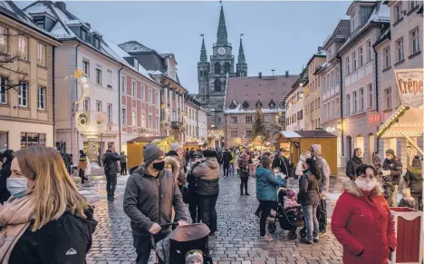  ?? THE NEWYORKTIM­ES LAETITIAVA­NCON/ ?? Patrons make their way around a Christmas market Dec. 5 in Ansbach, Germany. Across the country, city and town squares stand empty of the usual huts, sounds, scents and lights, as the coronaviru­s has forced the country to skip its beloved annual Christmas markets.