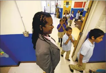  ?? Francine Orr Los Angeles Times ?? VIELKA McFARLANE watches students walk to class at Celerity Nascent Charter School in L.A. in 2011.