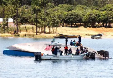  ??  ?? Tanzanian rescue workers search for victims, a day after the ferry MV Nyerere capsized in Lake Victoria. — AFP photo