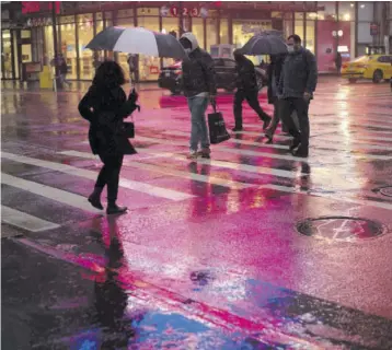  ?? (Photo: AP) ?? Shoppers walk in a rainstorm, Monday, November 30, 2020 in New York. With people staying home as virus cases surge, Cyber Monday is expected to be the biggest online shopping day yet, bringing in nearly US$13 billion in one day.